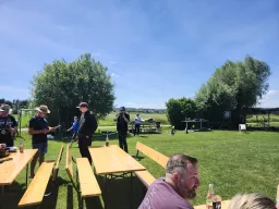 Pause an den Biertischen, im Hintergrund liegen Flugmodelle am Startbereich bereit