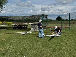 Zwei Modellflieger bereiten ihre Segelflugmodelle auf der Wiese für den Schlepp vor