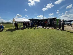 Piloten versammeln sich zum Briefing vor dem Vereinsheim, links ein weißer Pavillon