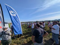 Teilnehmer beim Briefing neben der Fahne des Luftsport-Verbands Bayern