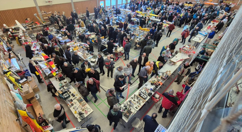 Übersicht des gut besuchten Modellbau-Flohmarkts in großer Sporthalle aus Vogelperspektive