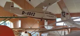 Weißes Segelflugzeug-Modell mit Kennung D-1012 und Modellbezeichnung Hüttter H17, aufgehängt in Innenraum mit Holzwänden