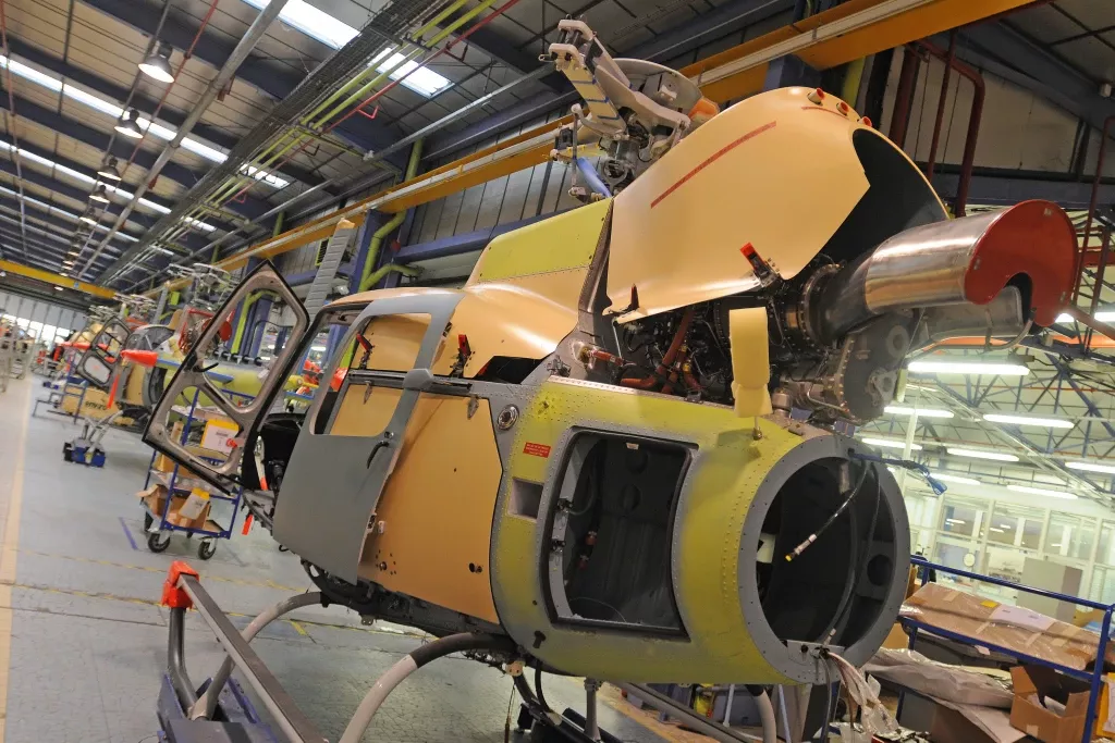 Gelb-graue Hubschrauber-Zelle in Produktionshalle, Airbus Helicopters Montagewerk mit Industrieausrüstung