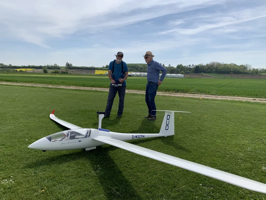 Zwei M&auml;nner mit wei&szlig;em Segelflugmodell auf gr&uuml;ner Wiese, Modell mit Kennzeichen D-KGTH